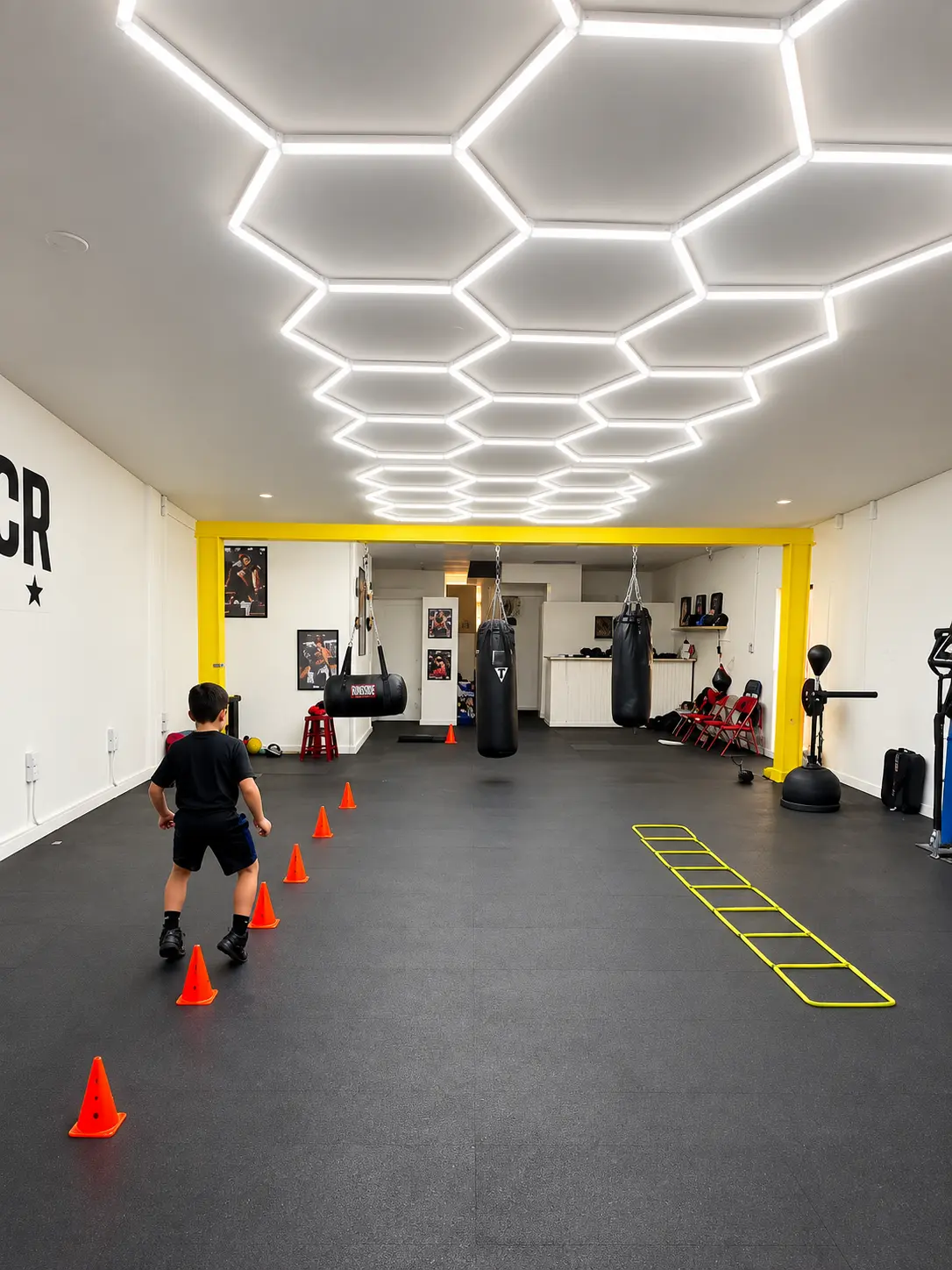 Wide view of the Vencedor training floor with heavy bags